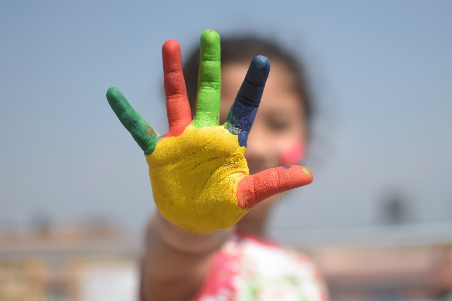 young child holding up five fingers